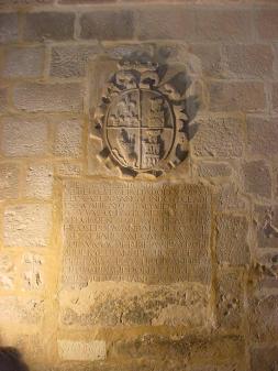 Escudo y lápida con inscripción en el muro de la capila de San Galindo