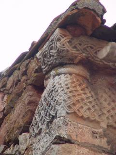 Capitel románico geminado con bella labor de cestería, colocado en el esquinazo de un alero de una vivienda