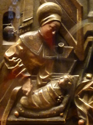 En un bajorrelieve en madera donde se representa el nacimiento de la Virgen, una sirvienta faja firmemente a la recién nacida con vendas