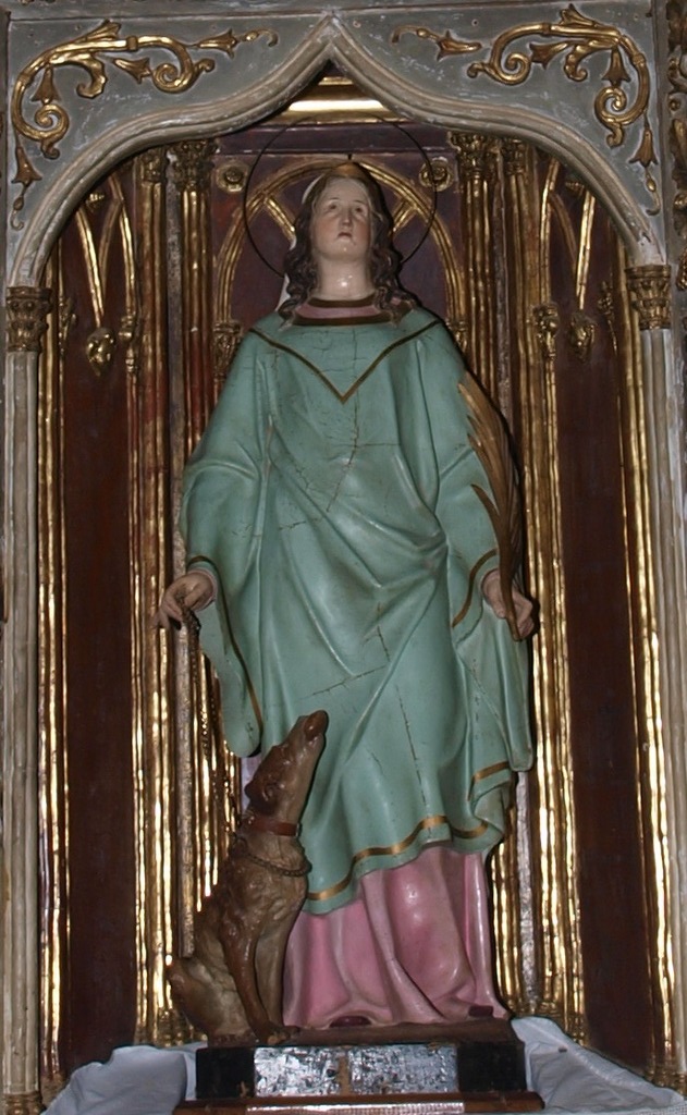 Una mujer con túnica azul claro dirige su mirada al cielo, mientras sujeta con una cadena un perro, el cual le ofrece un pan con la boca