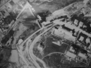 Fotografía aérea antigua de la zona de la subestación eléctrica y las escuelas públicas, donde se aprecia un círculo perfecto intersectado por una valla
